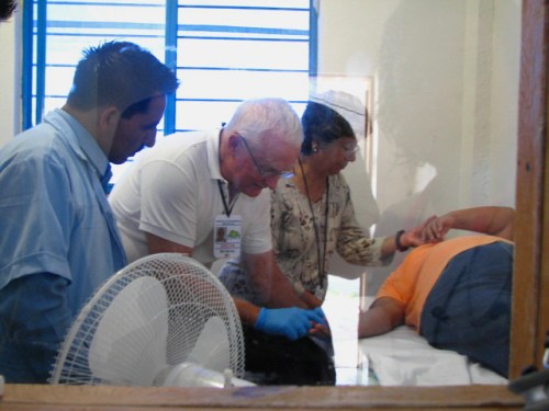 A Mexican EMT, Dr Bill Herring and an RN examine a patient
